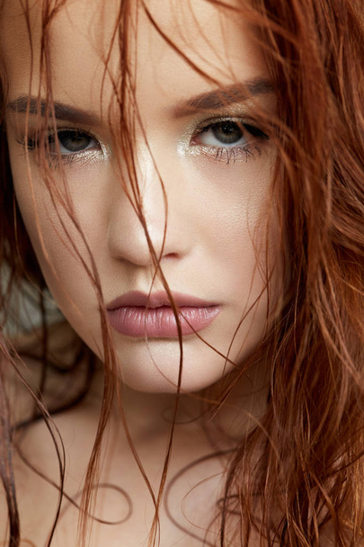 Young girl in a gentle way and red hair. Beautiful model with shining skin and nude makeup. Spring portrait. Beauty face. Hairs on  her face. - Foto, Bild