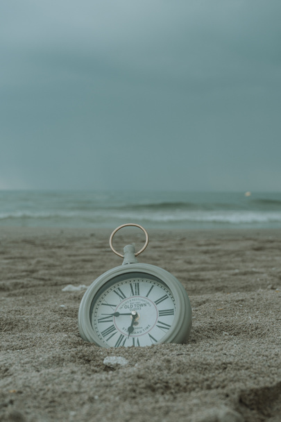 Reloj en la playa arena
 - Foto, Imagen