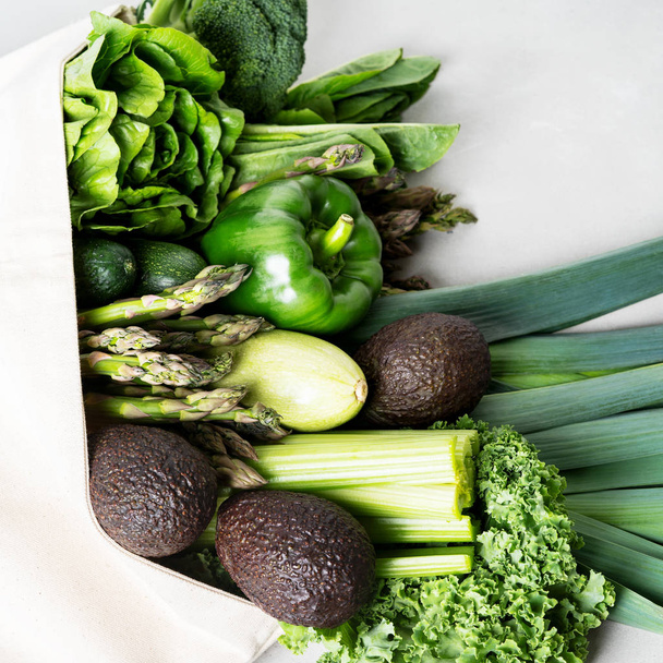 Taze yeşil sebze ve yeşillik beton arka plan üzerinde pamuk eko alışveriş çantası - Fotoğraf, Görsel