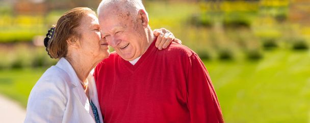 Χαρούμενο γηραιότερος ζευγάρι που έχει καλό χρόνο στο πάρκο της πόλης, περπάτημα, γελώντας και απολαμβάνοντας την ηλιόλουστη μέρα - Φωτογραφία, εικόνα