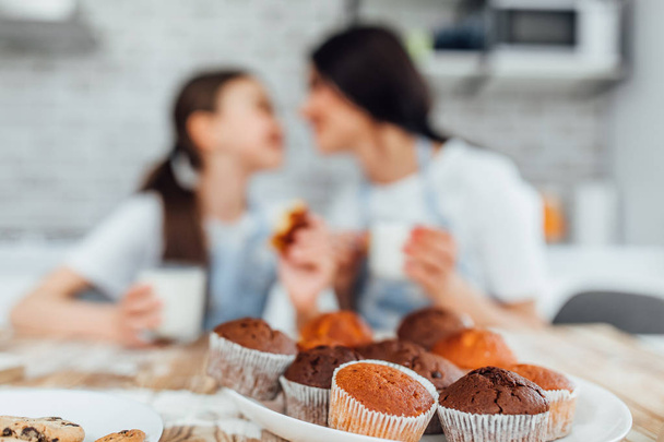 Perfect homemade muffins, sisters in background, selective focus - Foto, afbeelding