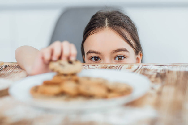 Kis lány lopás cookie, szelektív fókusz - Fotó, kép