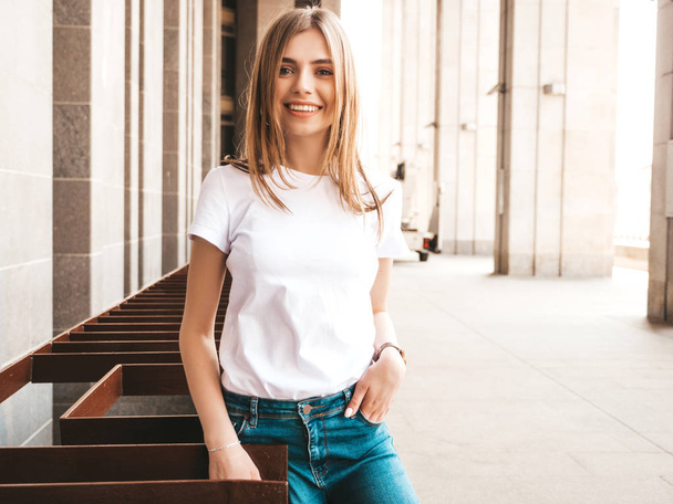 Portrait of beautiful blond model dressed in summer hipster clothes. Trendy girl posing in the street background. Funny and positive woman having fun - Foto, Imagen