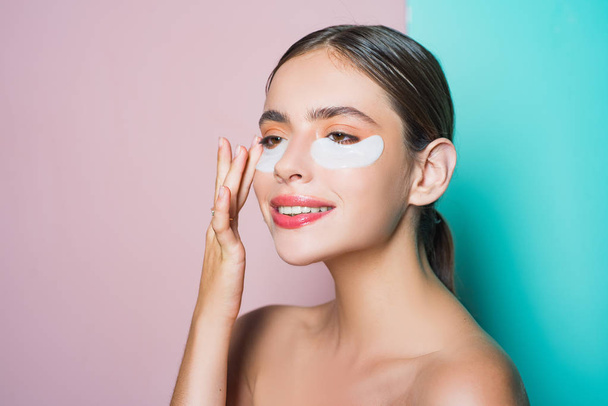 Moisturizing eye patches. Taking care of her skin. Woman using eye patches spending time at home. Daily pampering routine. First care than put make up on. Modern cosmetics. Eye patches concept - Foto, Bild