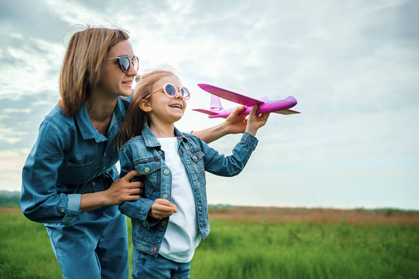 Mother and daughter playing with toy plane - 写真・画像