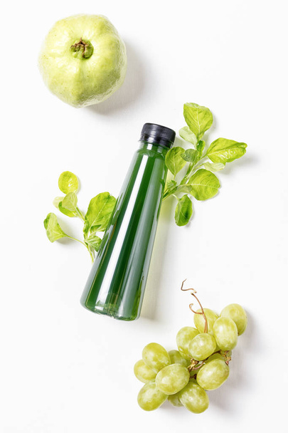top view flat lay bottle of juice with spinach, green greape and guava on white background. Healthy lifestyle, vegetarian food concept. Detox  - Foto, Imagen
