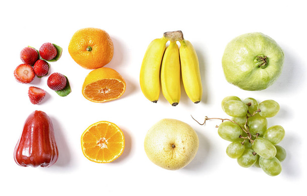Vers fruit in raaien op witte achtergrond. Rood, oranje, geel en groen. Voedselingrediënten, detox - Foto, afbeelding