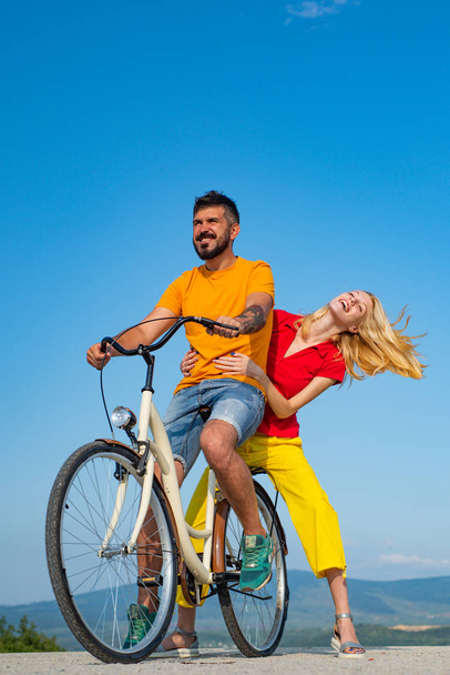 Travel Vacation concept. Young couple in love having fun and enjoying. Happy funny young couple riding on bicycle. Happy young couple riding bicycles. - Φωτογραφία, εικόνα