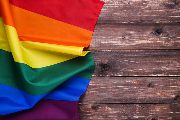 Rainbow flag on brown wooden table - Foto, Bild