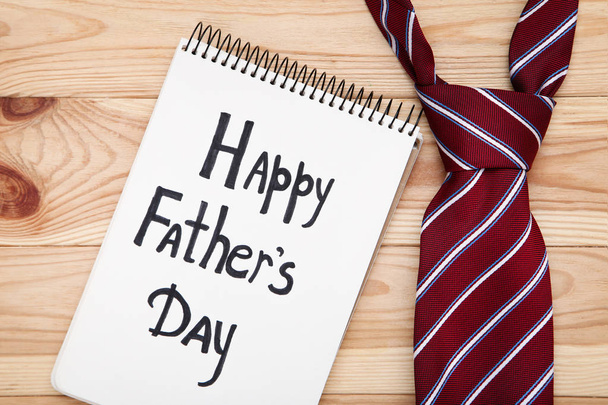 Text Happy Fathers Day with necktie on brown wooden table - Photo, image