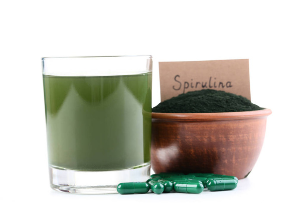 Spirulina drink and capsules with powder in bowl on white backgr - 写真・画像