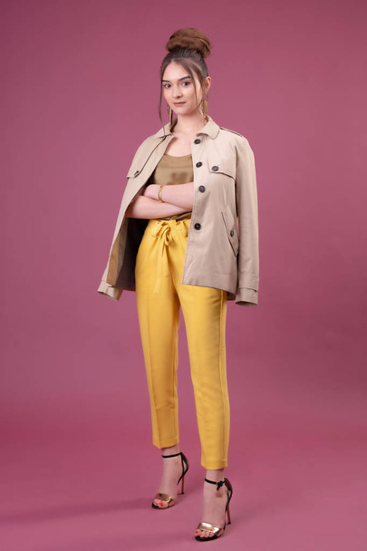 Portret van trendy jonge vrouw gekleed in gele broek - Foto, afbeelding