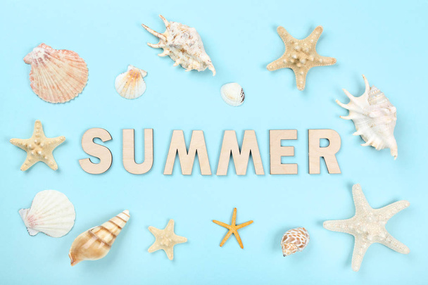 Word Summer with seashells on blue background - Foto, Imagen