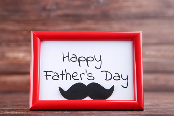 Text Happy Fathers Day in frame with black mustache on brown bac - Photo, Image