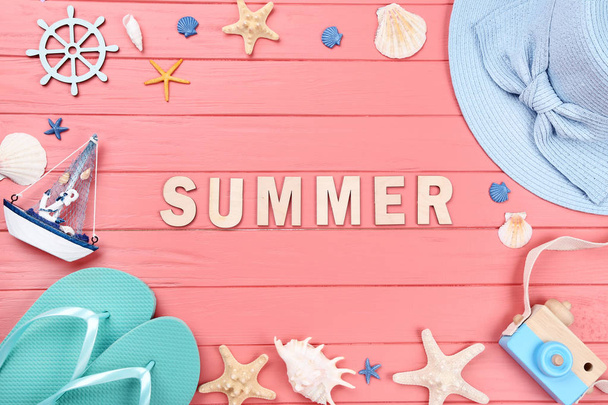 Word Summer with seashells and clothing on wooden table - Φωτογραφία, εικόνα