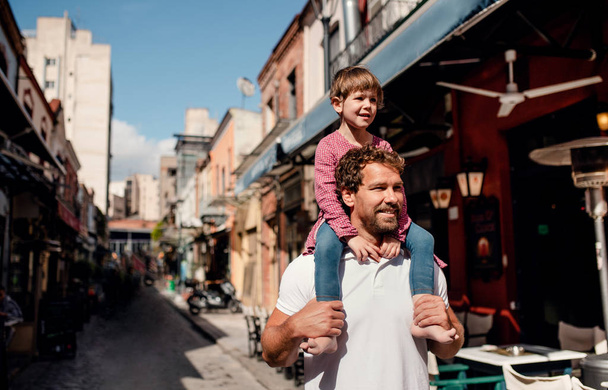Padre con hija pequeña de pie al aire libre en la ciudad mediterránea
. - Foto, imagen
