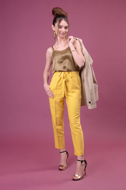 Portrait of fashionable young woman dressed in yellow pants - Фото, изображение