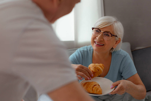 Face-portrait of lady preparing to eat a freshly-baked croissant - Photo, image