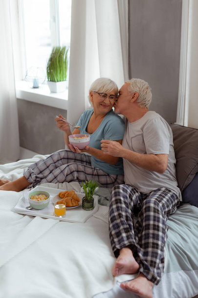 Loving spouse kissing his wife during breakfast in the bed - Foto, immagini