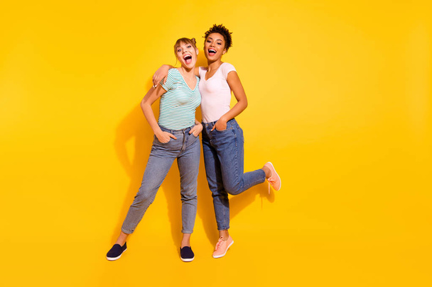 Full length body size photo beautiful she her lady laugh laughter buddies fellows different nationalities hands arms pockets wear casual white striped t-shirt clothes isolated yellow bright background - Foto, immagini
