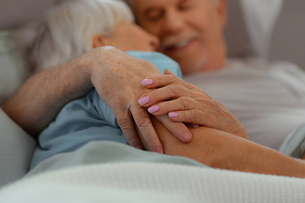Close-up of aged nice-appealing good-looking loving aged couple holding hands - Foto, imagen