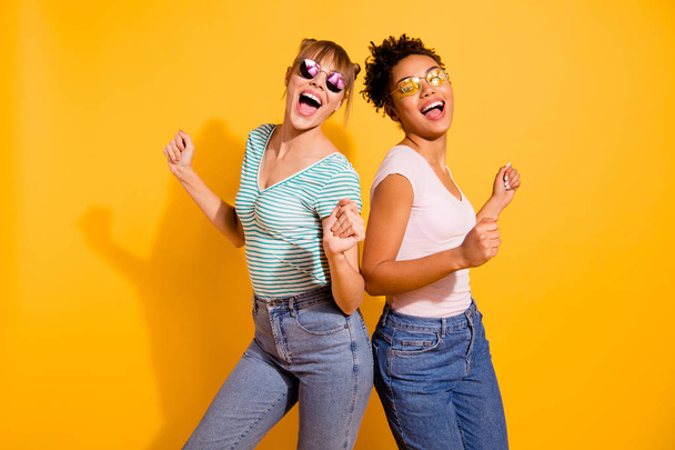 Close up photo beautiful funny she her lady party guys hands arms raised up modern motion different nationalities wear sun specs casual white striped t-shirt clothes isolated yellow bright background - Fotó, kép