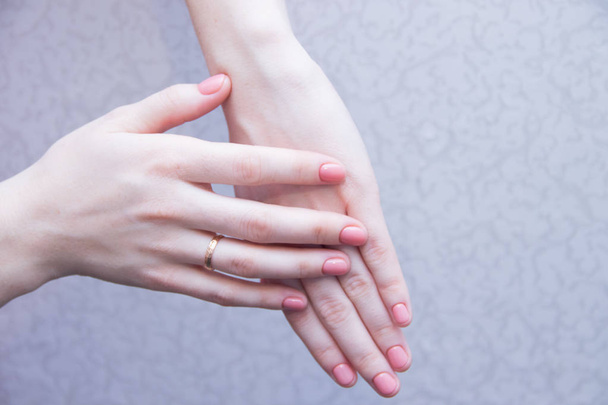 Růžovou plnou barevnou manikúru na ženské ruce. Jemná manikúra. Gelový lak. Dobře-rozkvetlo nehty. Monopfonní manikúra - Fotografie, Obrázek