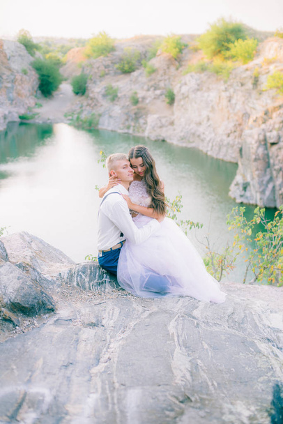 Elegant gentle stylish groom and bride near river or lake. Wedding couple in love  - Foto, Imagen