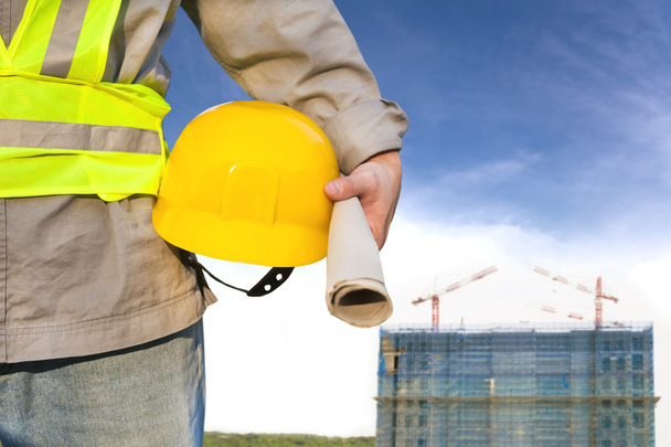 Construção edifício com trabalhador segurando chapéu
 - Foto, Imagem
