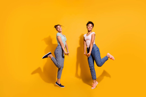 Full length body size view charming millennial nice pretty teens free time weekend summer candid rest relax jeans clothes wavy curly top-knot haircut style stylish trendy isolated yellow background - Fotoğraf, Görsel