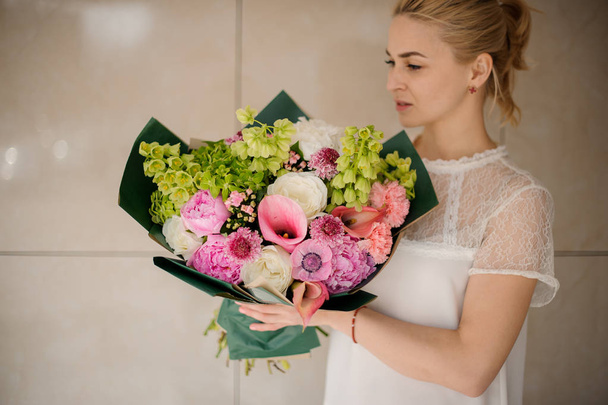 Young blond girl holds bouquet with various flowers - Foto, Imagem
