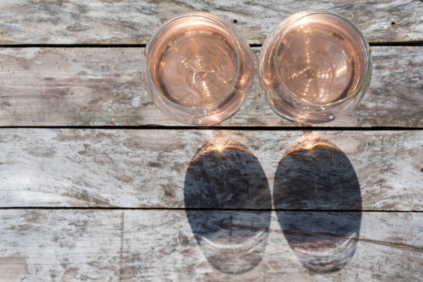 Two glasses of rose wine on a wooden table - Фото, зображення