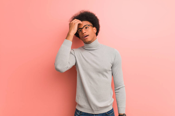 Fiatal afroamerikai férfi egy rózsaszín fal aggódó és túlterheltek - Fotó, kép