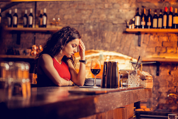 Woman having headache while waiting for man in bar - Foto, Imagem