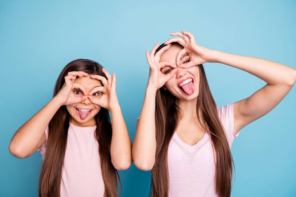Close-up portrait of two nice attractive lovely crazy cheerful cheery straight-haired girls showing tongue out ok-sign like glasses isolated over bright vivid shine green blue turquoise background - Zdjęcie, obraz