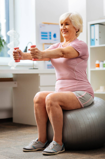 Active senior woman sitting on the fitness ball - Foto, imagen