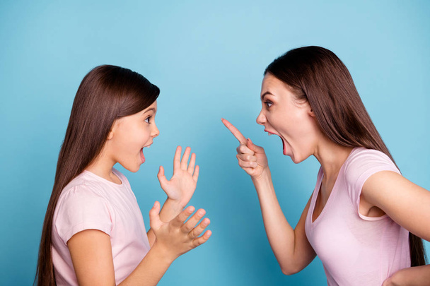 Close-up profile side view portrait of two nice attractive fury furious annoyed irritated straight-haired girls having fight disagreement isolated on bright vivid shine green blue turquoise background - Foto, Bild