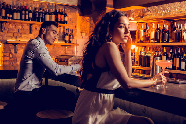 Man looking at beautiful curly woman in the bar - 写真・画像