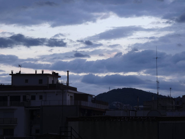 crépuscule, coucher du soleil, crépuscule dans la ville avec des antennes et des bâtiments en arrière-plan en contre-jour
 - Photo, image