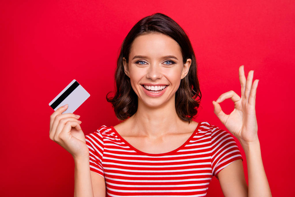 Close up photo cheerful charming lady positive satisfied advert alright good like fine choice decision advice promoter news discount black friday striped t-shirt trendy stylish isolated red background - Φωτογραφία, εικόνα