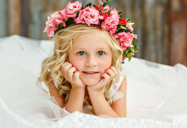 Image of sweet beautiful little girl with white hair wearing a natural flower crown. Large portrait. Looking at the camera - Zdjęcie, obraz