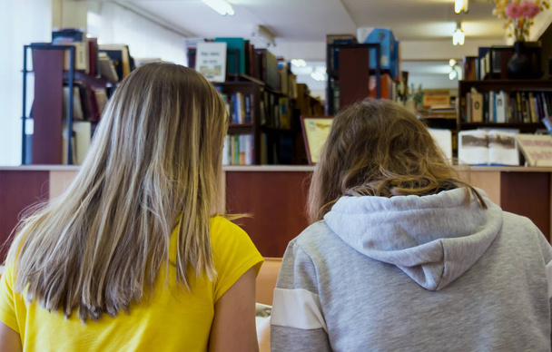 Two girls sitting in the reading room of the library - Foto, Imagen