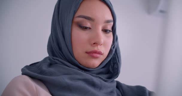 Close-up portrait of muslim businesswoman in hijab being busy distracts on camera and smiles joyfully into it. - Video