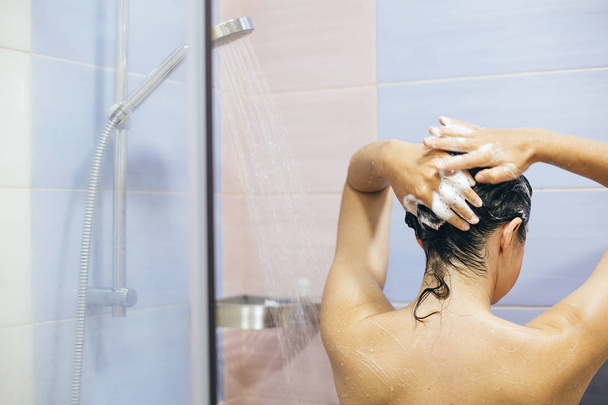 Genç mutlu kadın saçını şampuanla yıkıyor, köpüklü... - Fotoğraf, Görsel