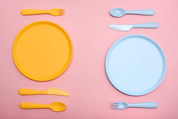 Colourful tableware for two persons on pink table. - 写真・画像