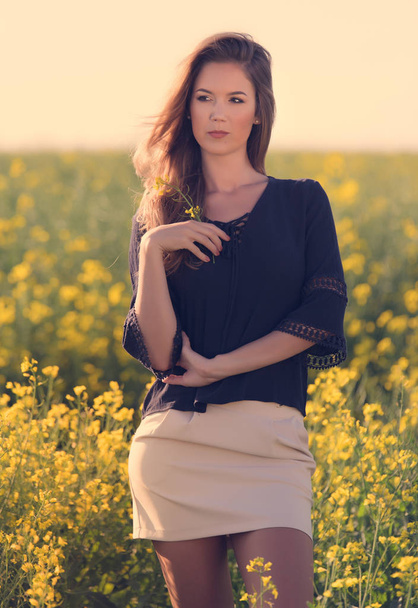 Portrait of beautiful woman in rapeseed field - Foto, afbeelding