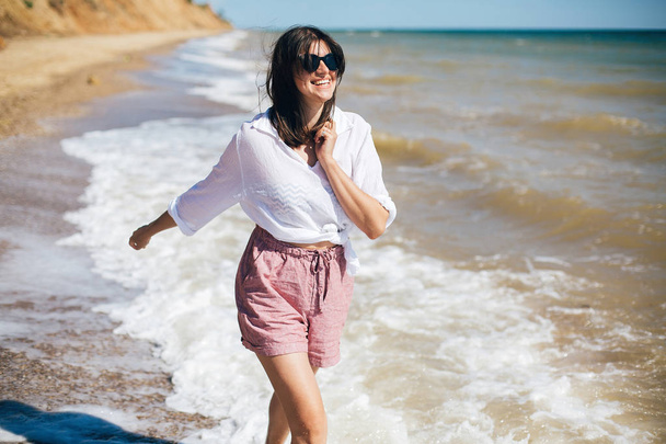 Szczęśliwa młoda kobieta Boho bieganie i uśmiechając się w fale morskie w słoneczne - Zdjęcie, obraz