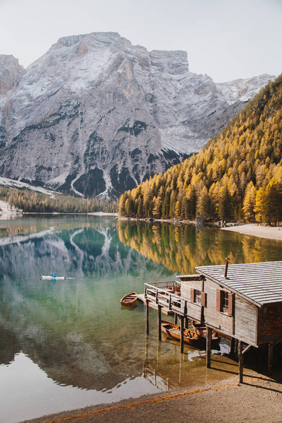 Young man kayaking on Lago di Braies in fall, Dolomites, South Tyrol, Italy - Foto, imagen