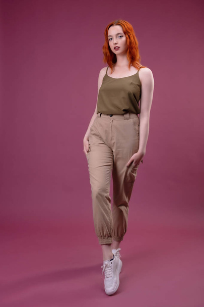 Full length portrait of a young girl standing over pink background - Photo, image
