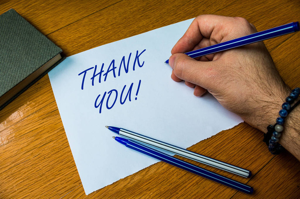 Handwriting text writing Thank You. Concept meaning polite expression used when acknowledging gift service compliment Top vie male handwriting wooden desk electronic device Writing down project. - Photo, Image